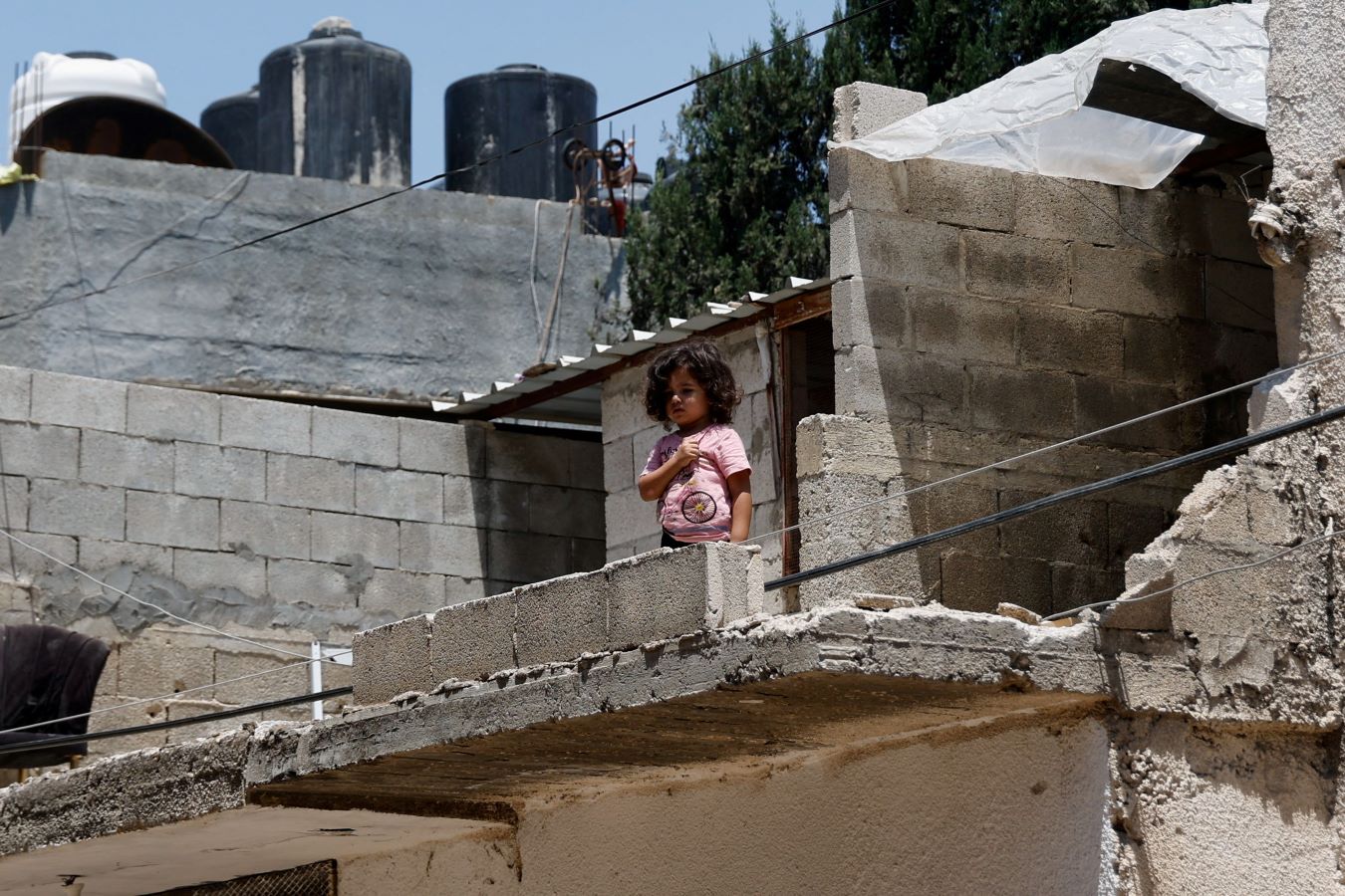 Una niña se de pie ante un edificio dañado luego de una operación militar israelí en el campo de refugiados de Yenin, en Cisjordania ocupada por Israel el 8 de julio de 2023. -RANEEN SAWAFTA / Reuters