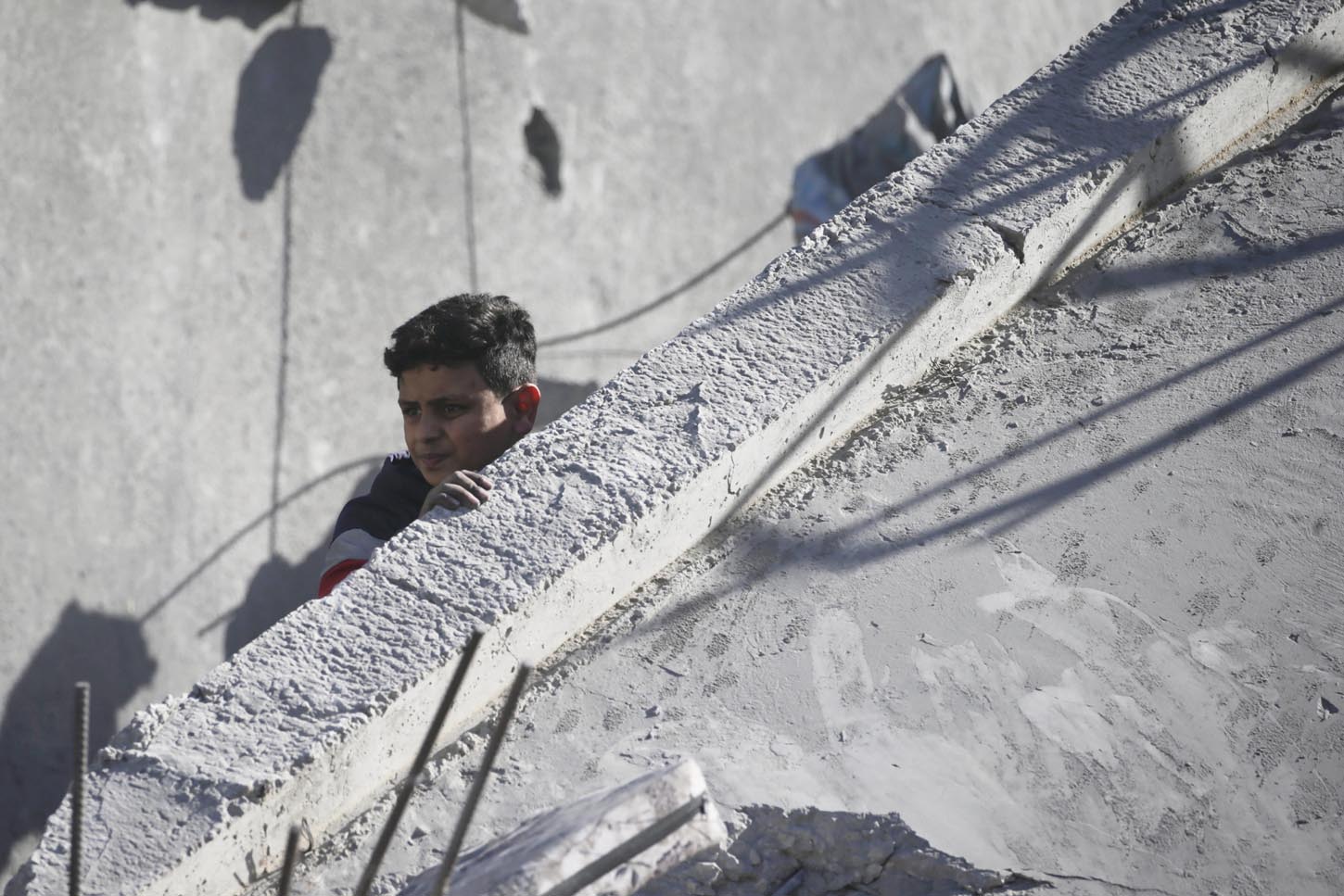 Un chico inspecciona los escombros de la casa destruida tras los ataques aéreos israelíes contra el campo de refugiados de Al Maghazi, al sur de la Franja de Gaza. EFE/EPA/MOHAMMED SABLE