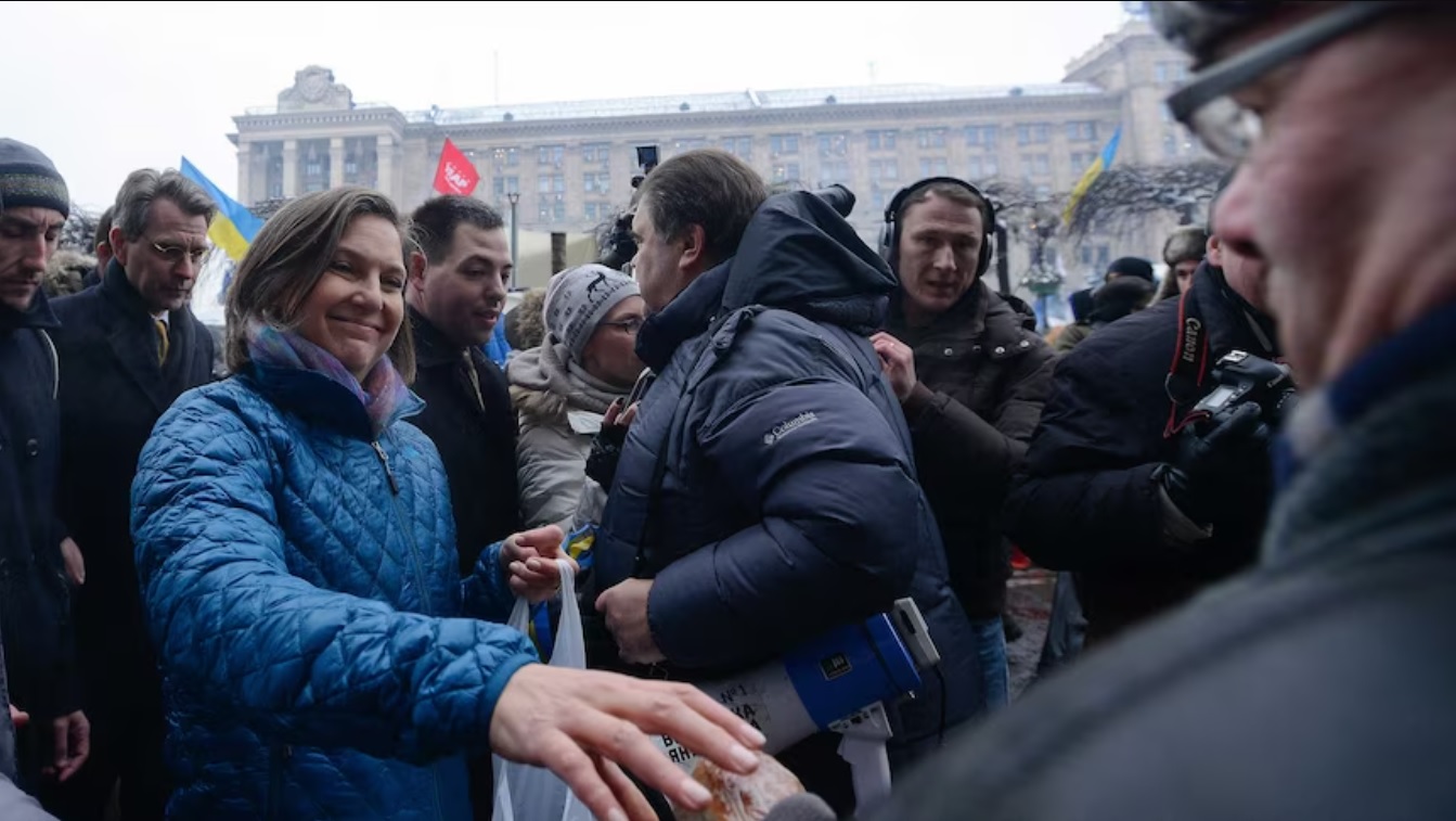 Victoria Nuland, en la foto distribuyendo pan a manifestantes políticos en Kiev en 2013, dice que Rusia está financiando y comandando la guerra en el este de Ucrania. ( Reuters: Andrés Kravchenko )