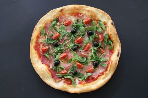 Receta de pizza casera con rúcula y tomate