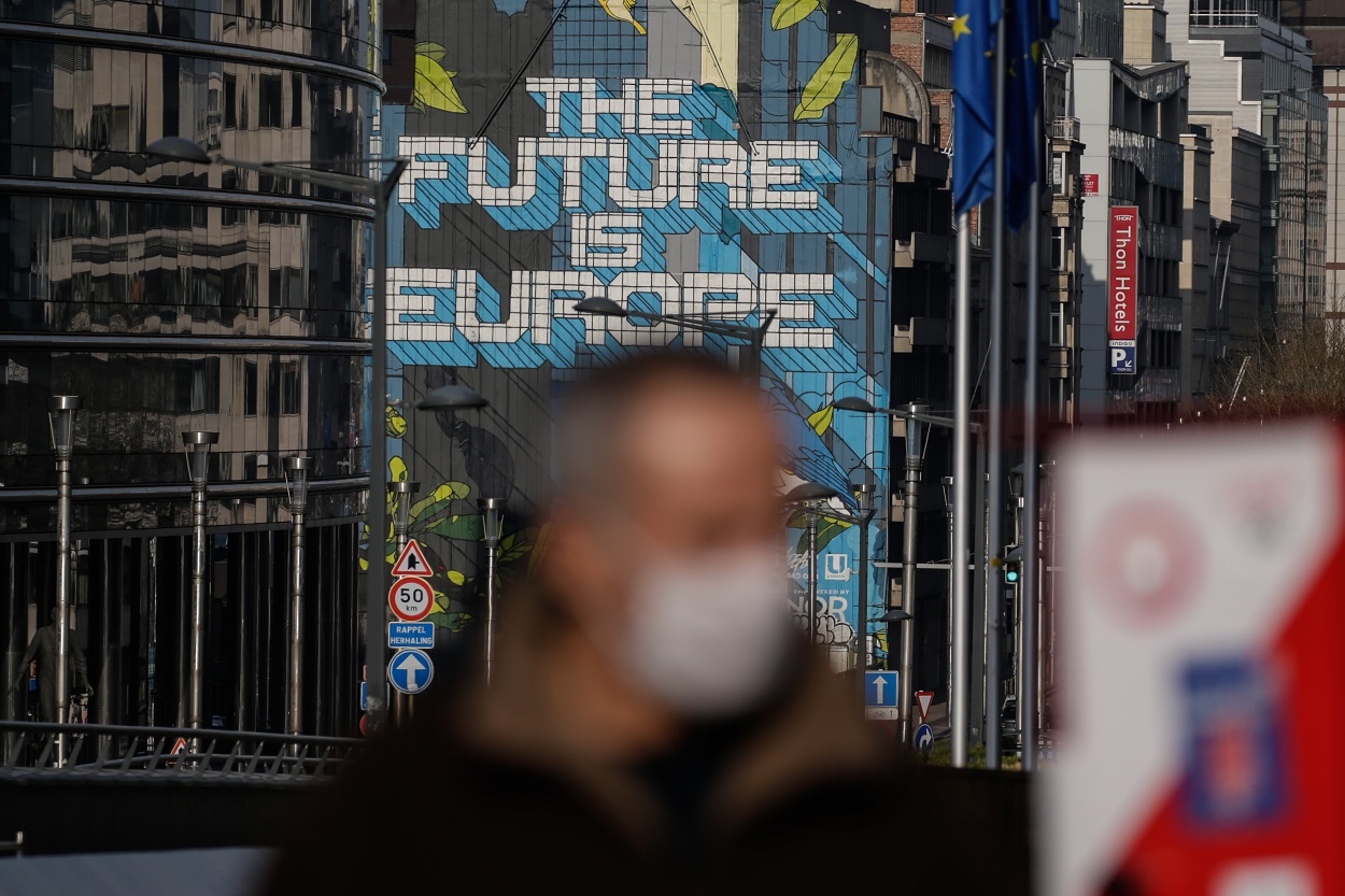 Un hombre con mascarilla pasa por delante del edificio de la Comisión Europea, en Bruselas. AFP/Aris Oikonomou