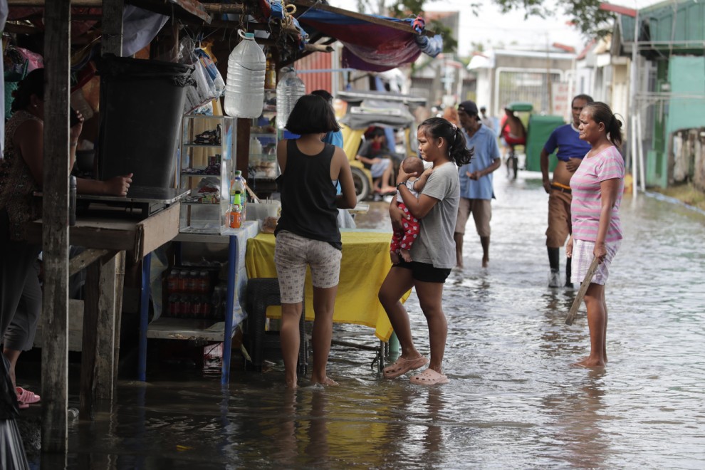 Diverses persones visiten un cementiri inundat a Kawit (Filipines) pels efectes d'un tifó. — Francis R. Malasig / EFE