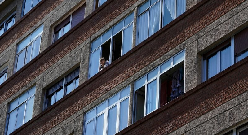 Una mujer mira desde una de las ventanas de su vivienda en Bilbao. REUTERS/Vincent West